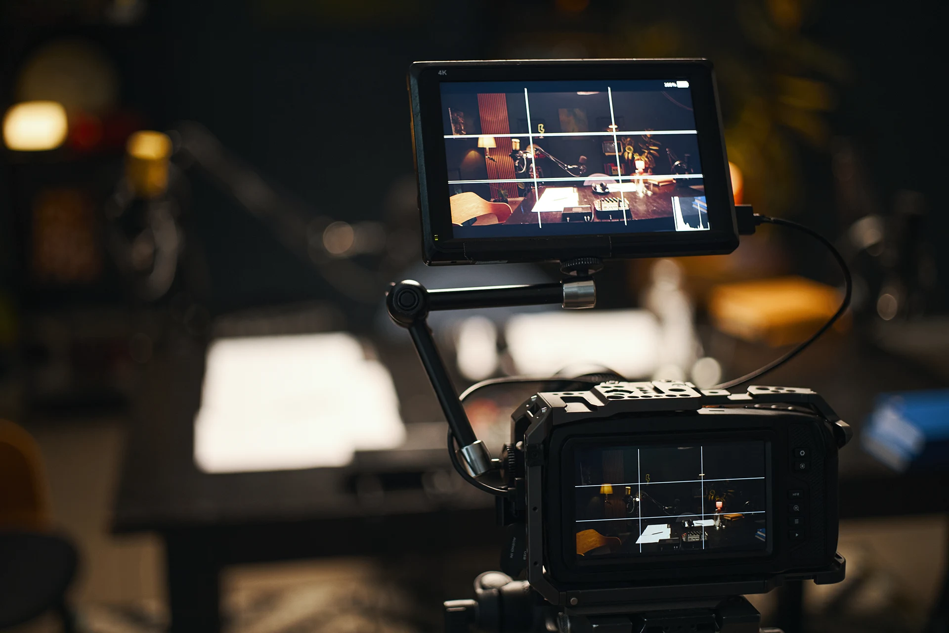 Cinema camera with a 4K on-set monitor framing a warmly lit studio set
