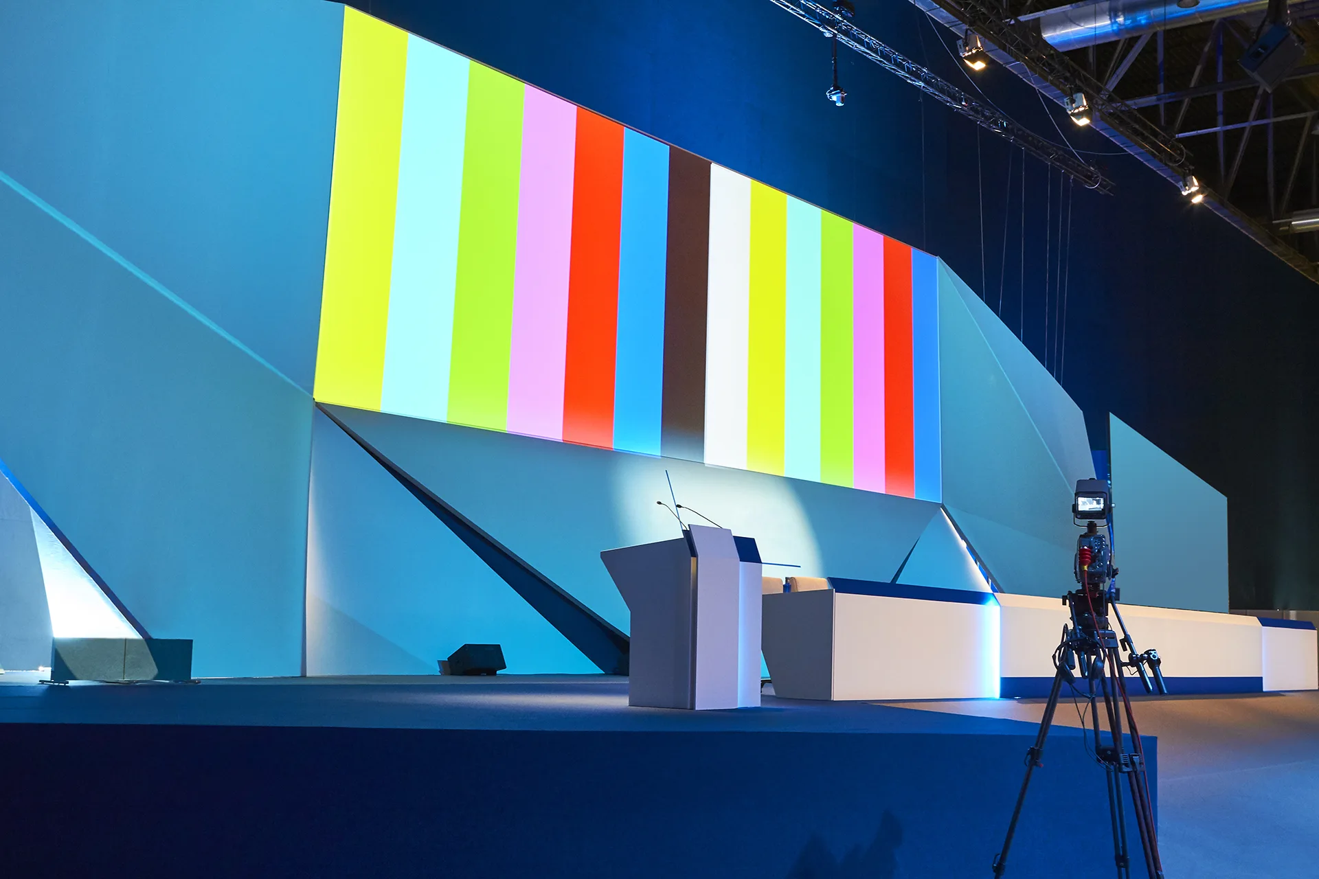 LED wall displaying color bars on a studio stage with a broadcast camera